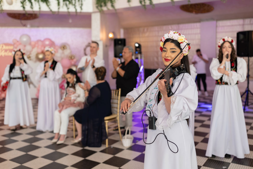 ursitoarele canta la vioara la botez, close-up filmat de videograf cu un setup multicam de 3 camere video
